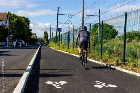 Cycliste profitant d'une piste cyclable goudronnée avec vue sur la nature