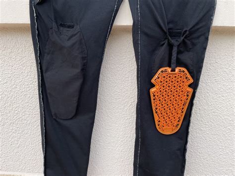 Schéma montrant l'emplacement des protections sur un pantalon de moto femme (genoux, hanches)