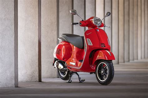 Détail des éléments de design sportif de la Vespa GTS 300 Super Sport : jantes bicolores, ressort de suspension rouge, selle spécifique.