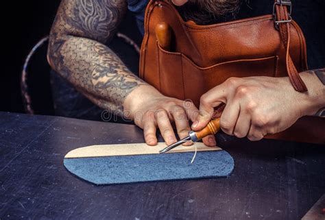 Gros plan sur des mains d'artisan travaillant le cuir pour une botte