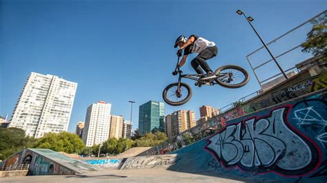 Photographe capturant un rider BMX en plein saut dans un skatepark intérieur.
