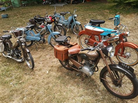 Scène de collectionneurs admirant des mobylettes anciennes dans un rassemblement