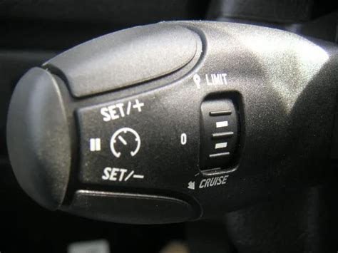 Vue du commodo gauche avec les commandes du régulateur de vitesse adaptatif et du menu