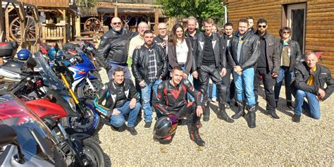 Groupe de motards partant en convoi, drapeau de l'association 