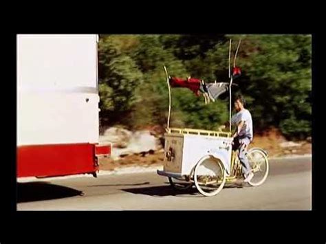 Darry Cowl souriant au volant de son triporteur