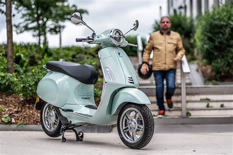 Vespa électrique garée près d'un vignoble.