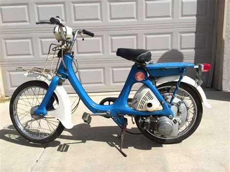 Photographie d'époque d'un cyclomoteur Honda P50, mettant en évidence son moteur intégré dans la roue arrière.