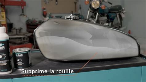 Technicien effectuant un débosselage sur un réservoir de moto