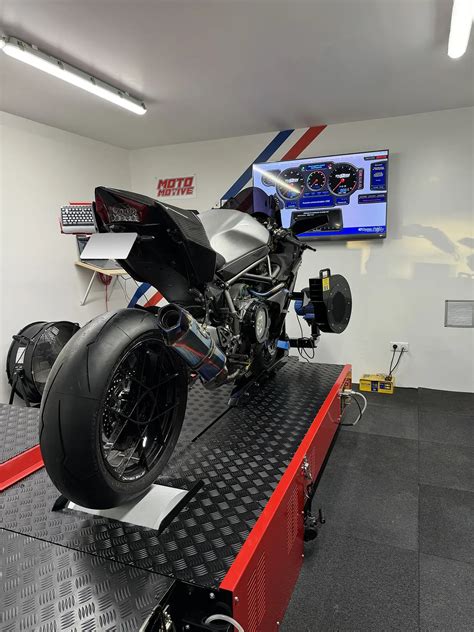 Photo d'une moto sur un banc de puissance dans un atelier de mécanique