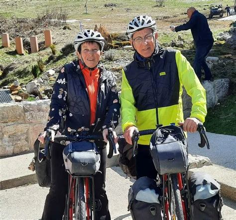 Photo d'un couple souriant avec leurs vélos chargés, prêts pour une longue expédition