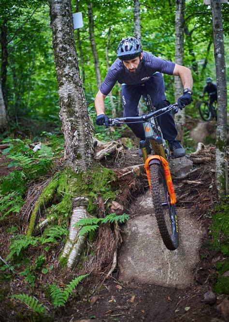 Cycliste VTT descendant un sentier étroit et technique en forêt