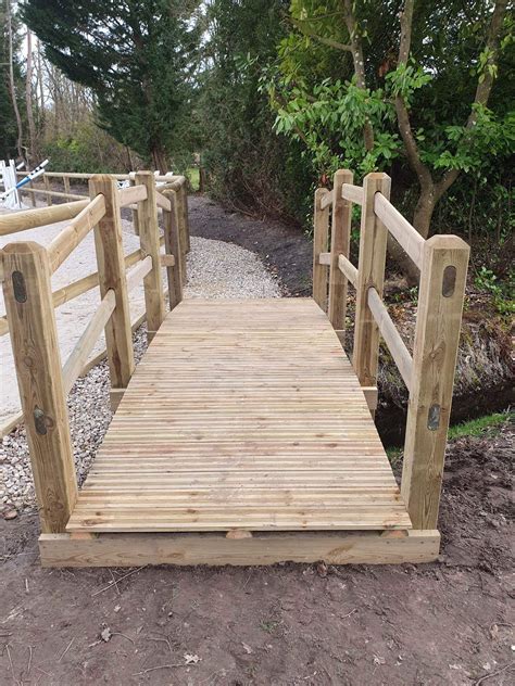 Goupe de vététistes traversant un pont en bois sur un sentier de randonnée