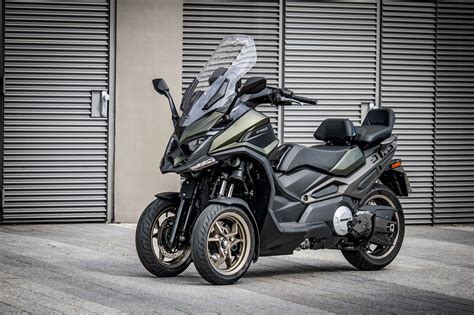 Photo comparative de l'éclairage standard et amélioré d'un scooter Kymco CV3 de nuit.
