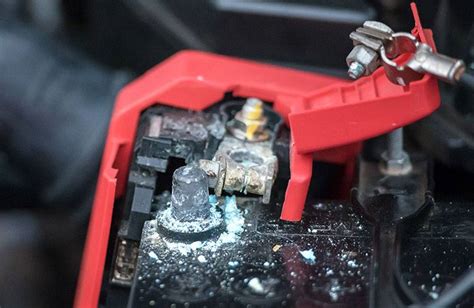 Photo montrant le nettoyage des bornes d'une batterie de moto