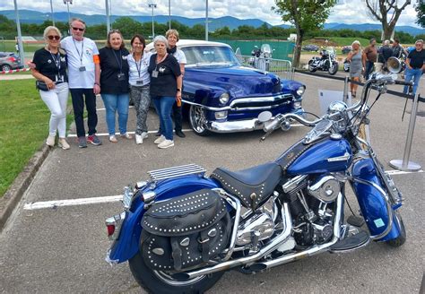 Une Harley-Davidson Softail Springer bleue, similaire à celle de Johnny Hallyday, garée devant une église.