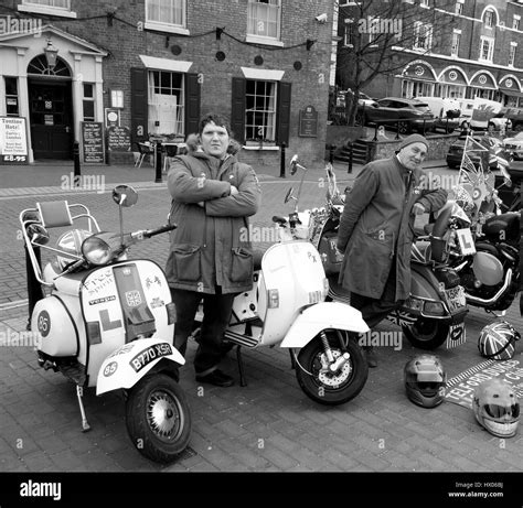 Photographie d'un groupe de Mods avec leurs scooters Vespa devant un club