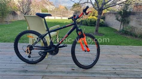Vue latérale du vélo 24 pouces B'TWIN montrant le garde-boue et d'autres équipements