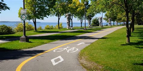 Piste cyclable le long des berges de l'Oise avec des arbres et un plan d'eau