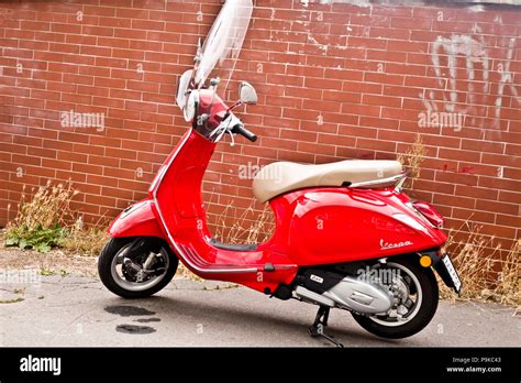 Photo d'une Vespa Primavera rouge avec le top case assorti et éventuellement un exemple de sac intérieur.