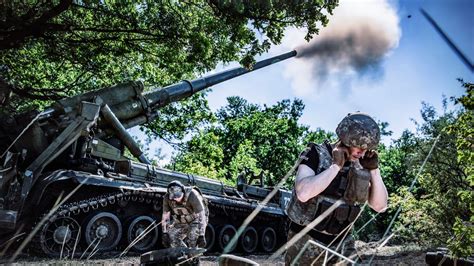 Image d'un soldat russe sur un vélo à proximité d'un véhicule de combat BMP.