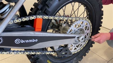 Schéma expliquant comment vérifier la tension d'une chaîne de moto