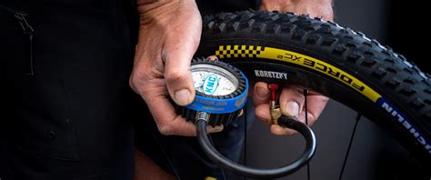 Infographie expliquant comment ajuster la pression des pneus de VTT selon le terrain et le poids du cycliste.