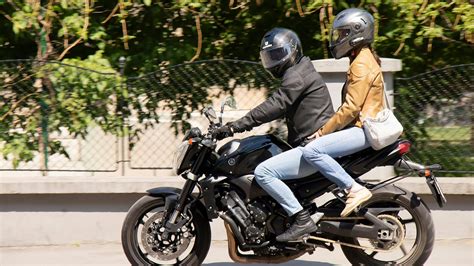 Illustration d'une moto avec et sans passager, symbolisant le changement dans l'examen.