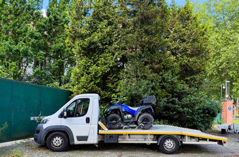 Photo d'une moto chargée dans un camion de transport spécialisé