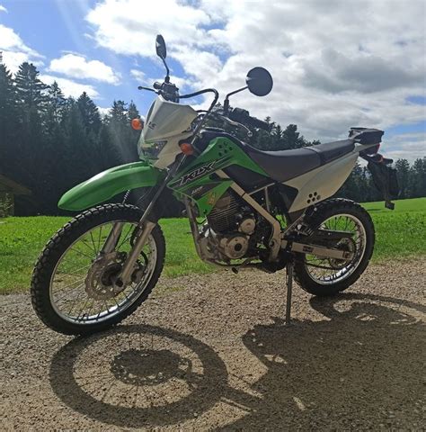 Vue latérale de la Kawasaki KLX 125, mettant en avant ses pneus à tétines et ses jantes à rayons