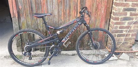 Schéma du VTT Moma Bikes Equinox 29 montrant le cadre en aluminium et les systèmes de suspension avant et arrière.