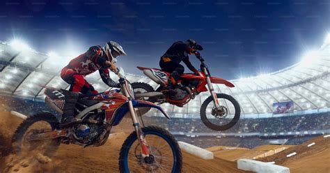 Photographie d'une course de motocross avec des pilotes en action et des spectateurs.