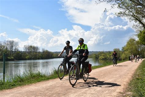 Cyclistes longeant une rivière sur la Voie Bleue