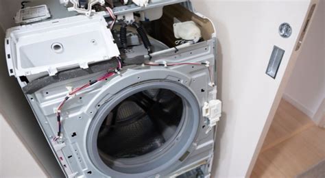 Vue arrière d'un lave-linge avec le panneau retiré, montrant l'emplacement du moteur