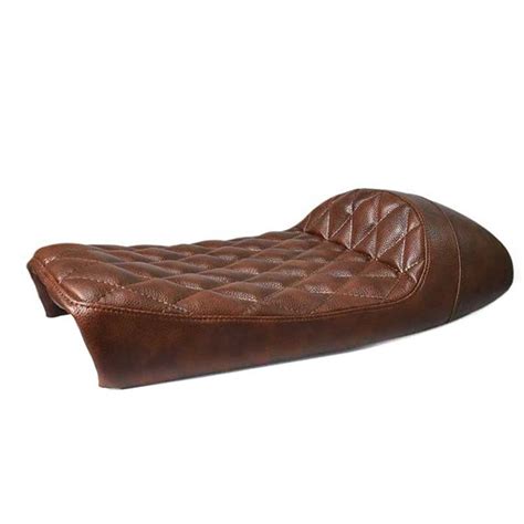 Une moto customisée avec une selle Café Racer noire, mettant en avant son profil classique et sa finition en simili cuir.