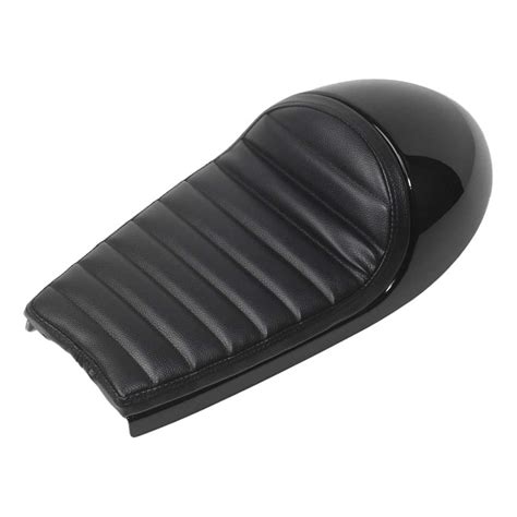 Gros plan sur les coutures d'une selle Café Racer noire, montrant différentes formes et styles.