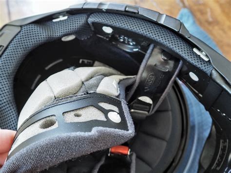 Illustration montrant comment retirer les joues intérieures d'un casque pour accéder au mécanisme de la visière.