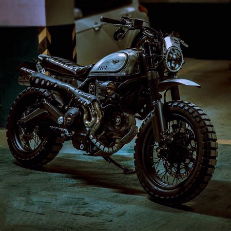 Illustration d'une moto de type scrambler équipée de pneus à crampons