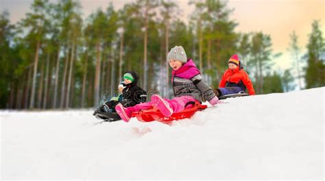 Enfants riant en glissant sur des tubes dans une pente enneigée