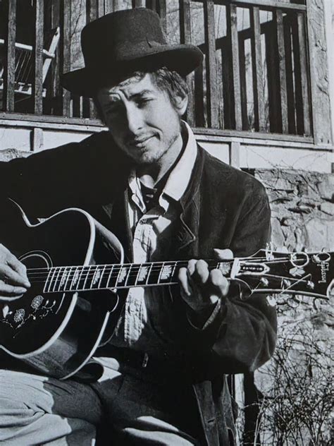 Bob Dylan jouant de la guitare acoustique