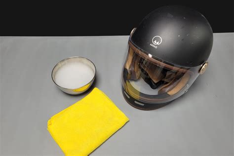 Nettoyage d'une visière de casque moto avec un chiffon microfibre