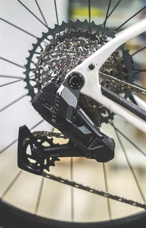 Photo d'une batterie SRAM AXS et de son emplacement sur le dérailleur