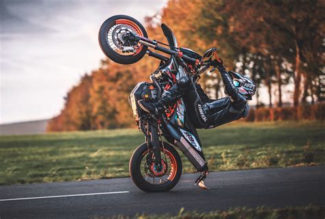 Photo d'un motard supermotard en plein virage avec le pied sorti