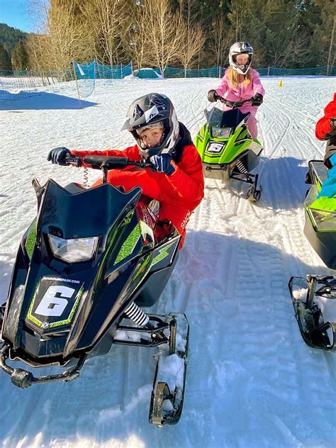 Enfants pilotant une motoneige électrique dans une station de ski