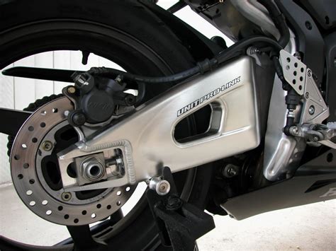 Gros plan sur des diabolos GBRacing 8mm fixés sur un bras oscillant de moto
