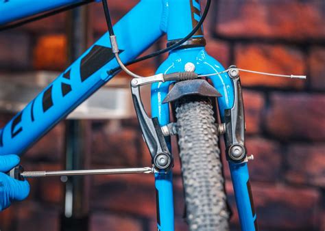 Gros plan sur une molette de réglage de compression bleue sur une suspension de VTT
