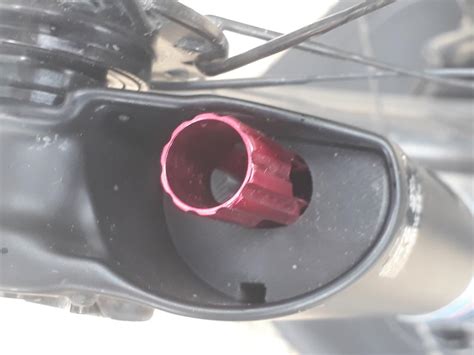 Gros plan sur une molette de réglage de détente rouge sur une suspension de VTT