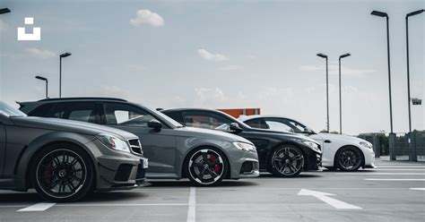 Groupe de voitures anciennes garées lors d'un rassemblement mensuel, montrant la diversité des modèles et des propriétaires.