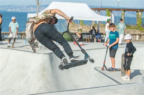 Groupe de jeunes pratiquant le freestyle en trottinette dans un skatepark