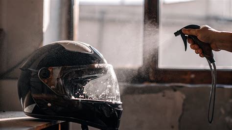 Nettoyage d'une visière de casque de moto avec un chiffon microfibre