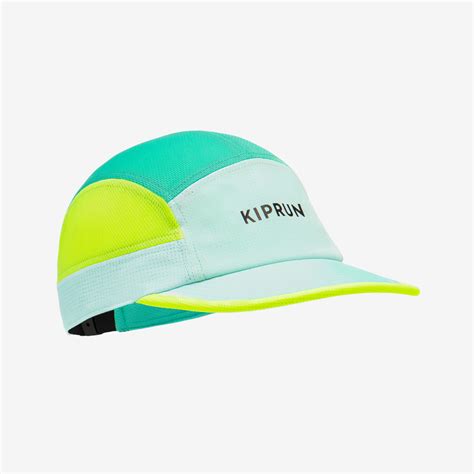 Vue de face d'une casquette de running avec quatre LED allumées dans la visière, éclairant un chemin.